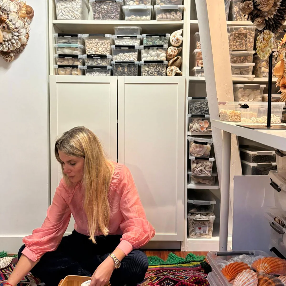 Sandrine Peten travaillant dans son atelier entourée de coquillages